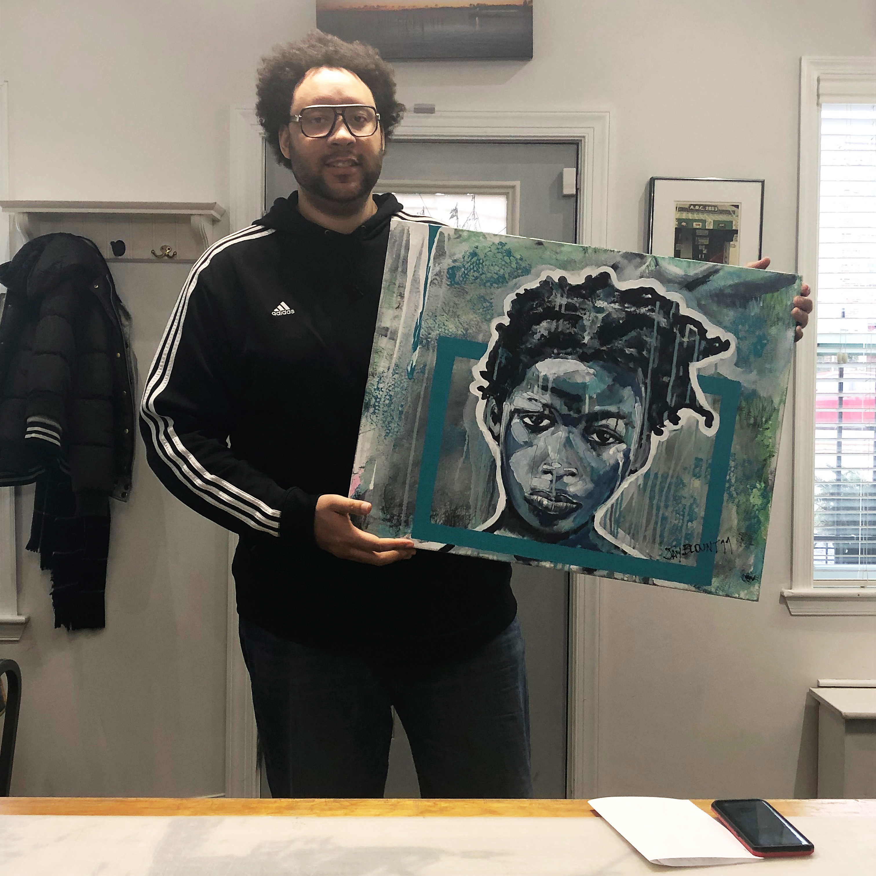 Artist Jay Blount poses with his painting of a portrait