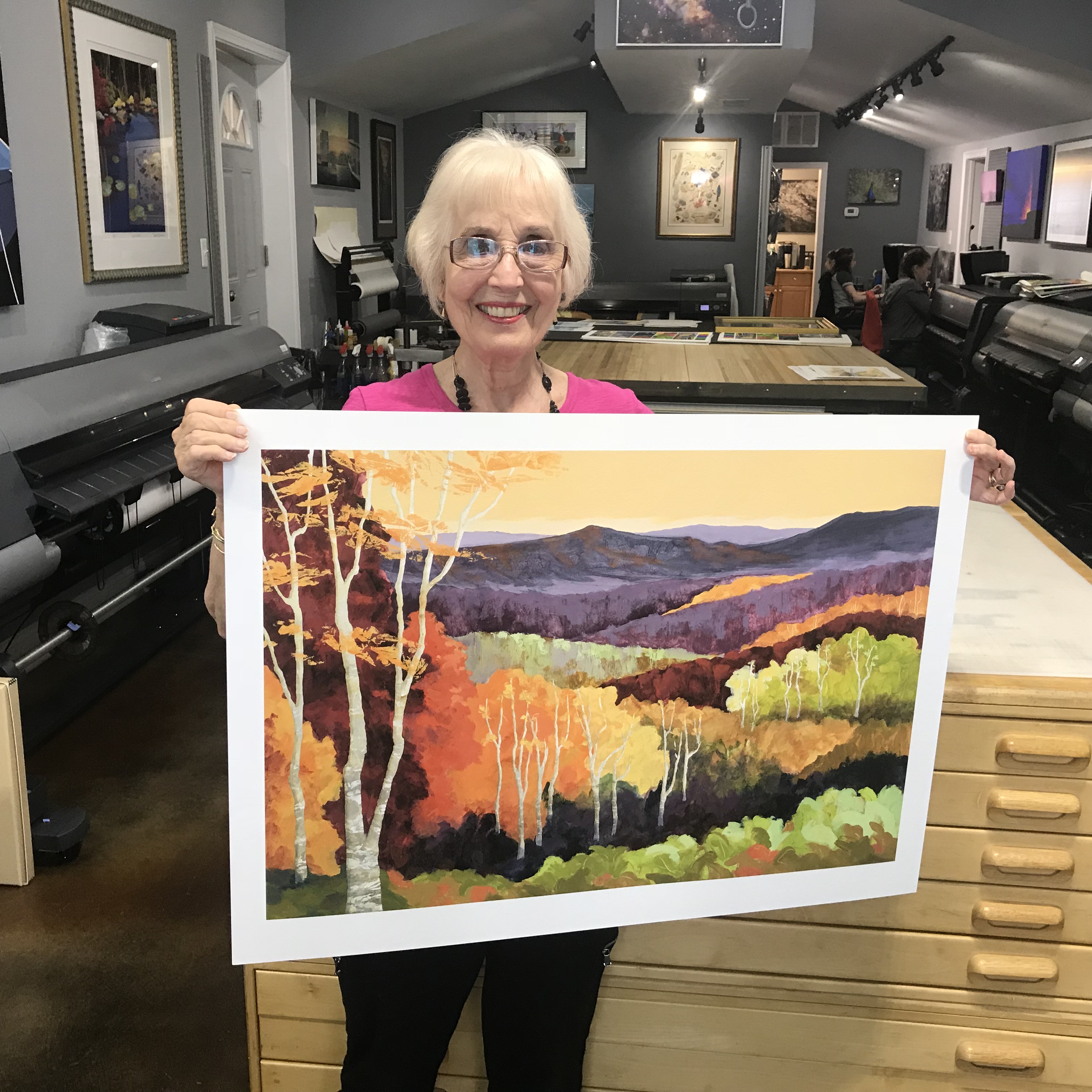 Artist Alvena McCormick poses with a print of her painting, "Hills of Color"