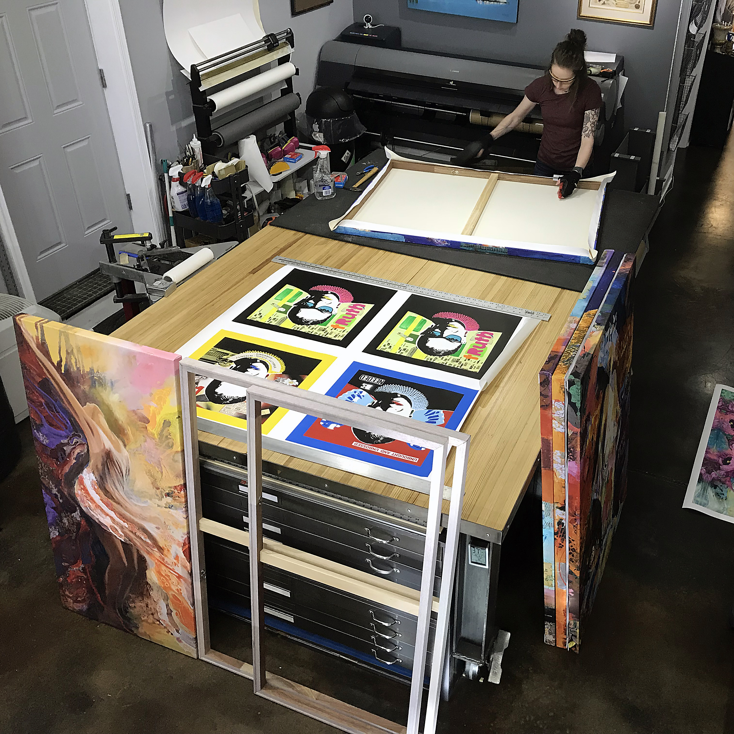 Aerial photography of Alexandria, Virginia studio table, with canvases being stretched, and more waiting to be stretched