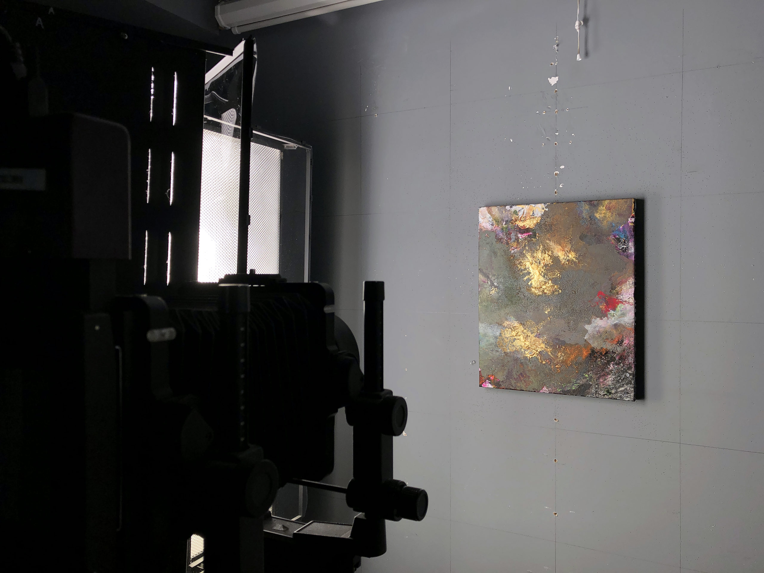 A painting with heavy texture being photographed